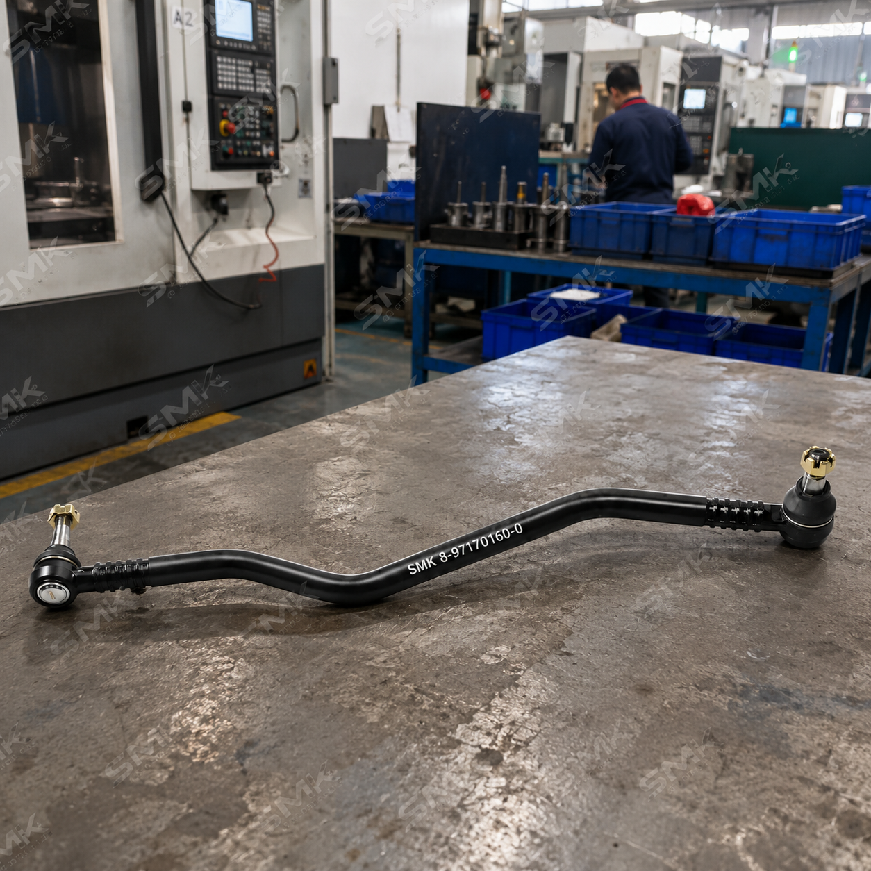 SMK curved heavy-duty truck drag link assembly on factory workbench